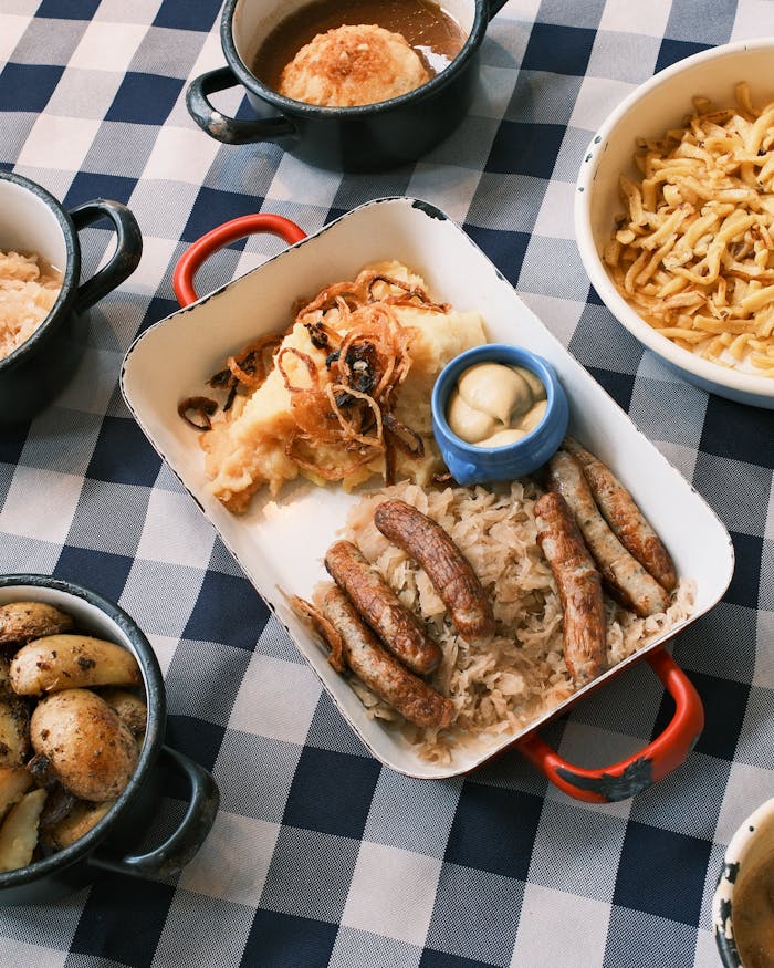Delicious Bavarian sausages and sides served elegantly on a checkered tablecloth.